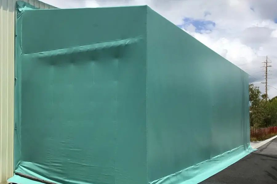 大型倉庫の外壁を覆う防塵・防風用途の屋外用ビニールシート施工例
